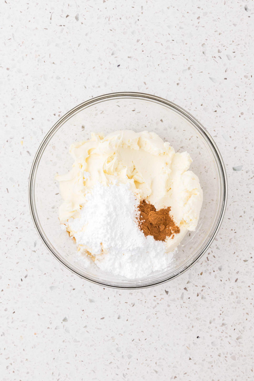 Mascarpone cheese, powdered sugar, and cinnamon in a bowl.