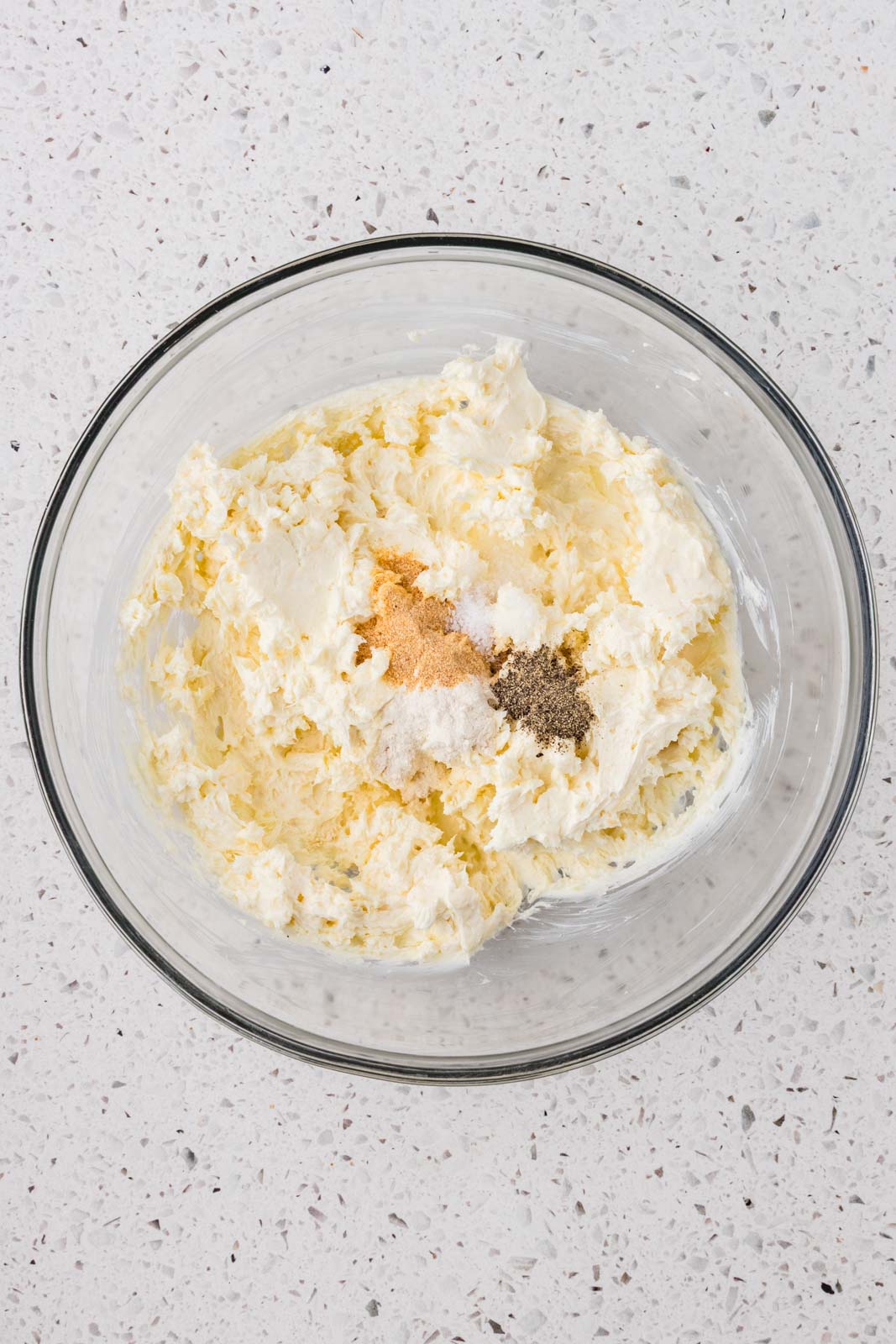 Cream cheese and seasonings in a bowl.