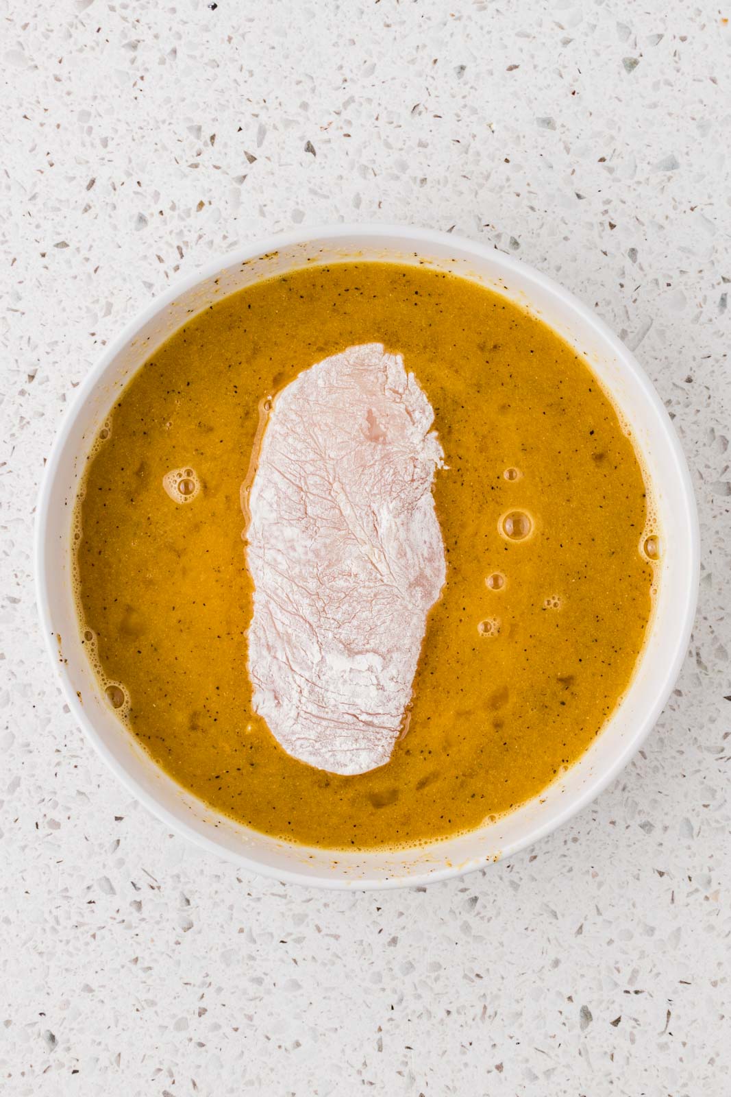 Chicken cutlet dipped in egg mixture.