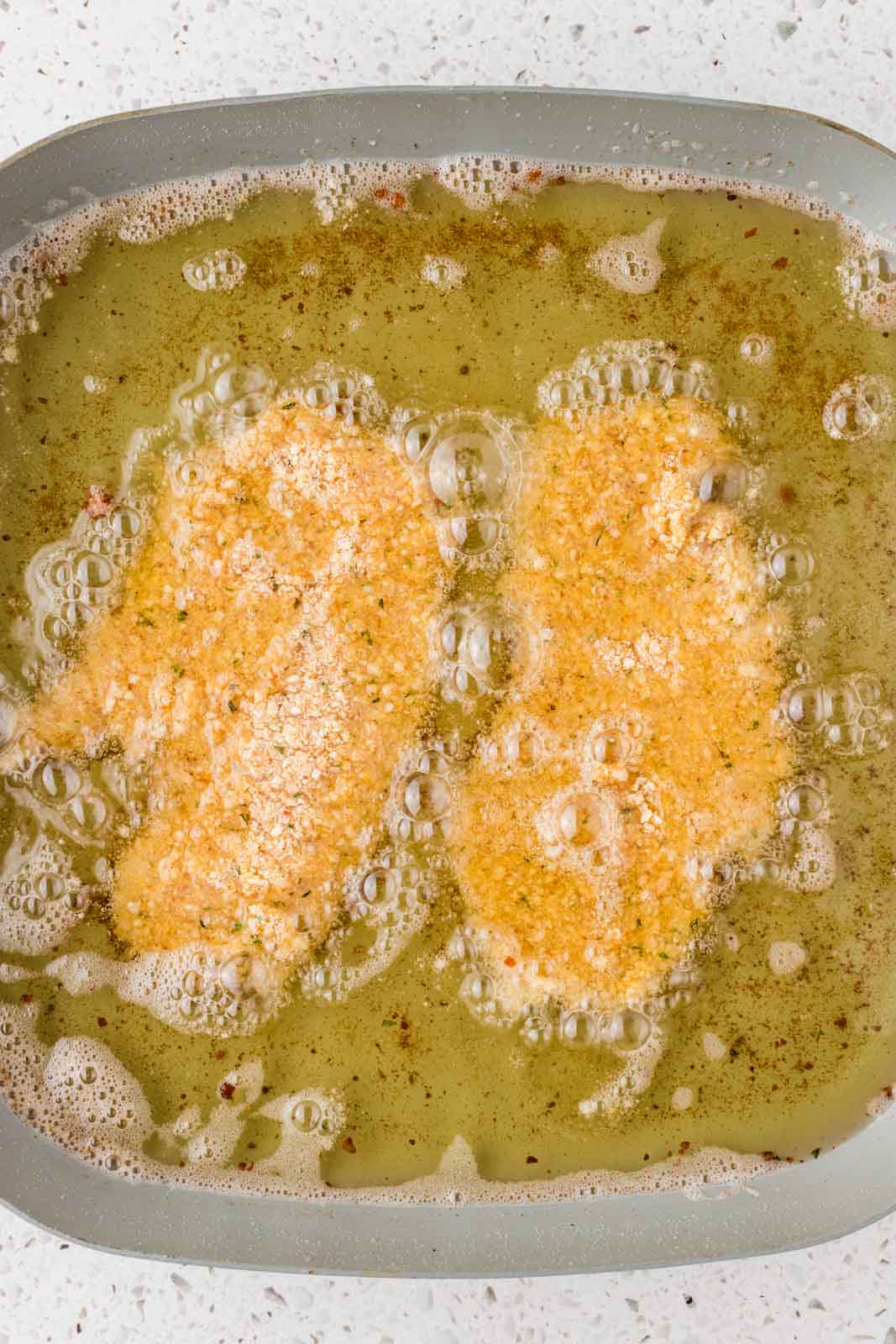 Chicken cutlets cooking in hot oil.